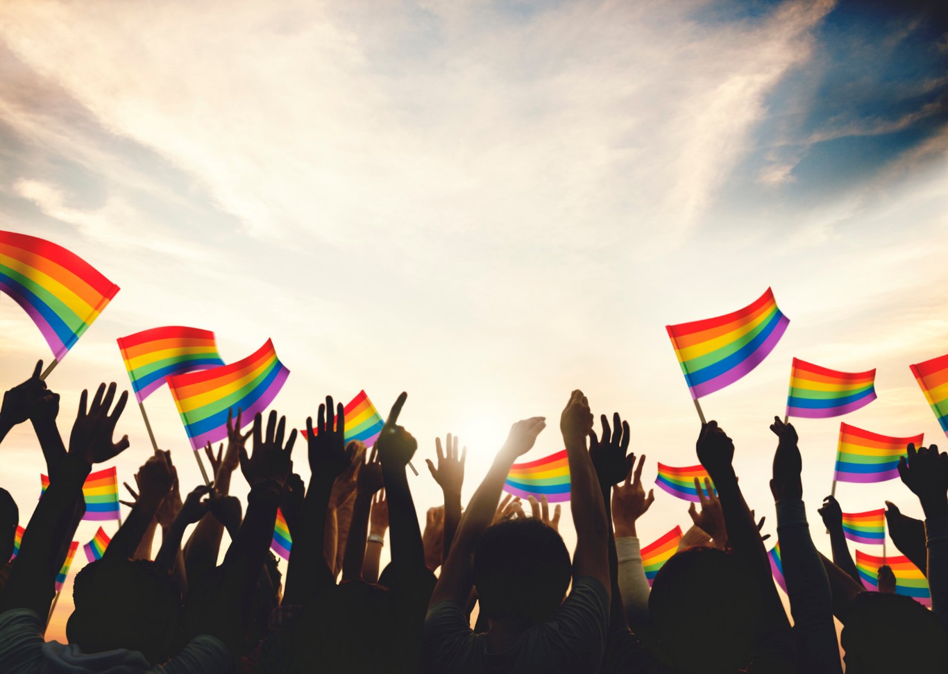 bandeiras lgbt nas mãos de várias pessoas em parada gay