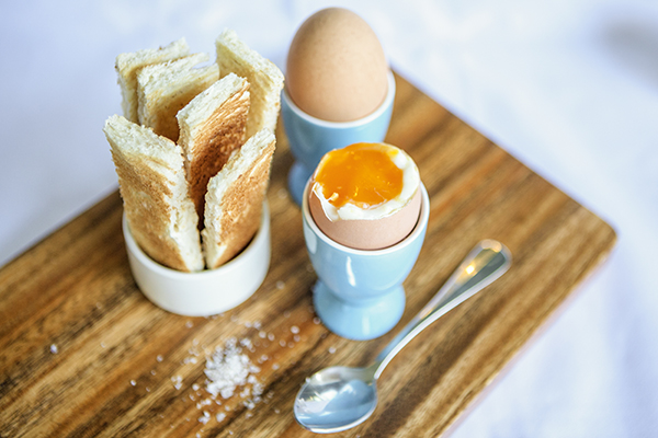 Delicious soft boiled eggs on a platter with toast 