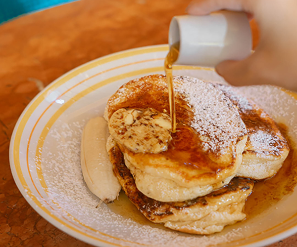 Ricotta hotcakes served warm with banana and honeycomb butter