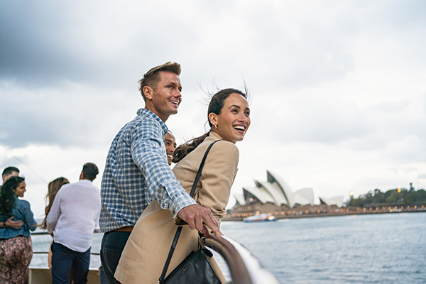 Couple enjoying harbour views aboard a Captain Cook Cruises vessel in Sydney Harbour.