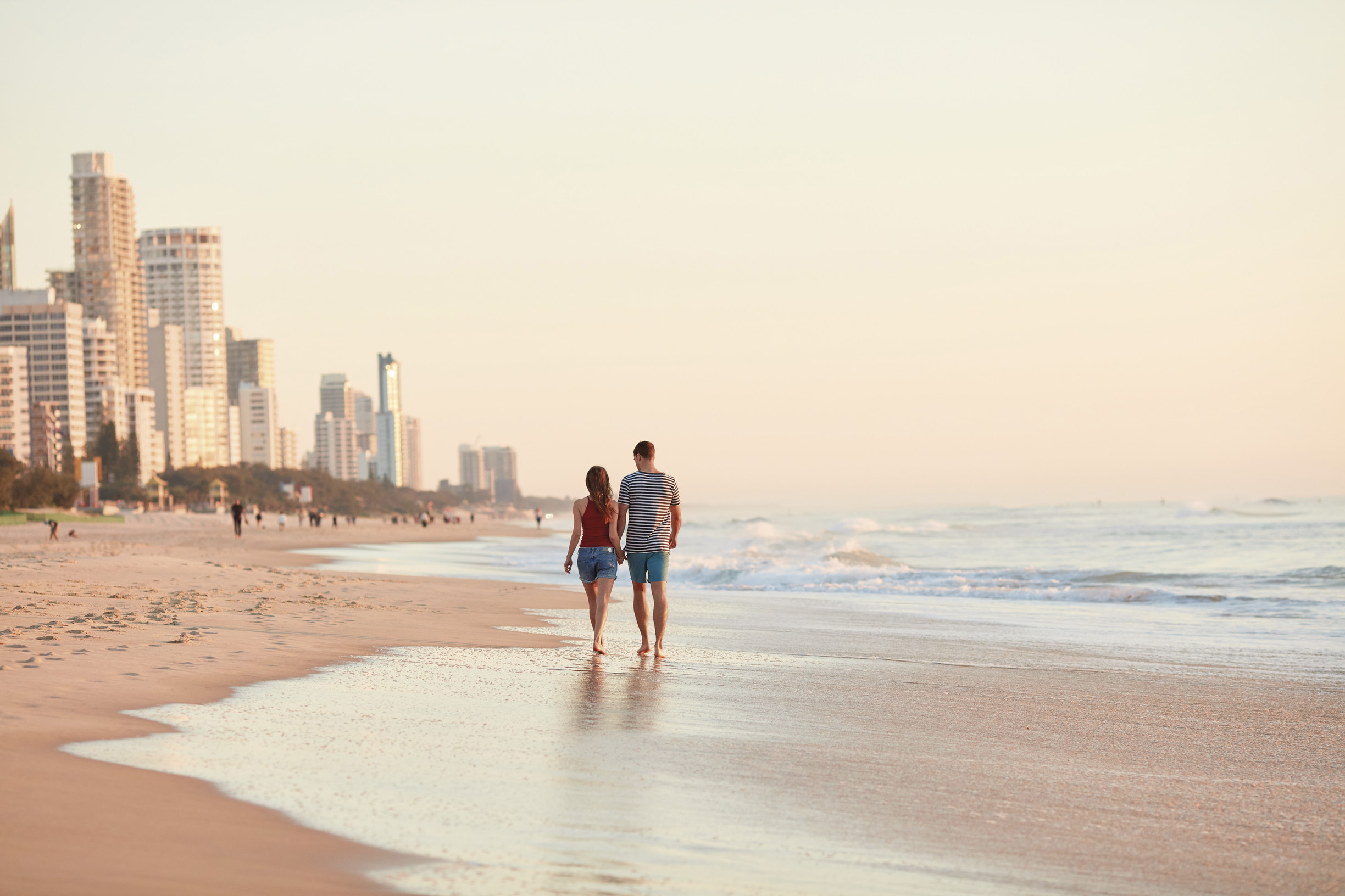 couple walking along Surfers Paradise beach 