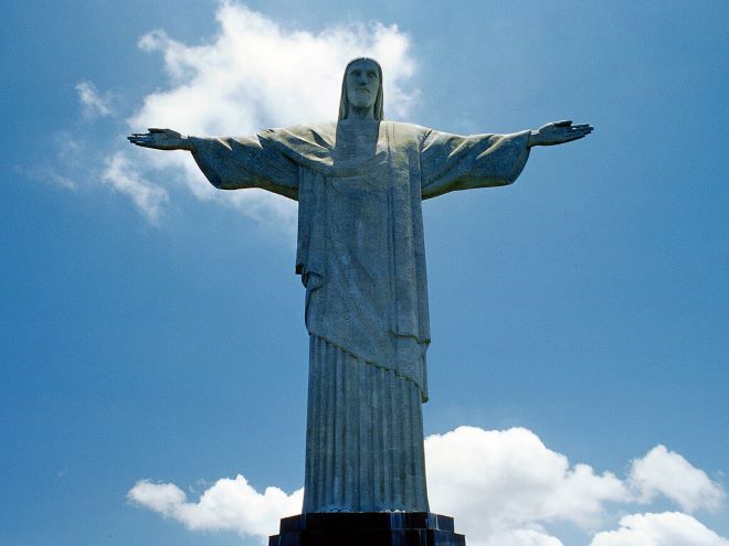 Estátua do Cristo Redentor no Rio de Janeiro com céu azul ao fundo e algumas nuvens brancas