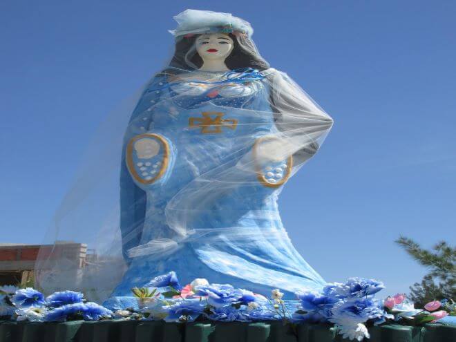 estátua de Iemanjá com flores azuis nos pés