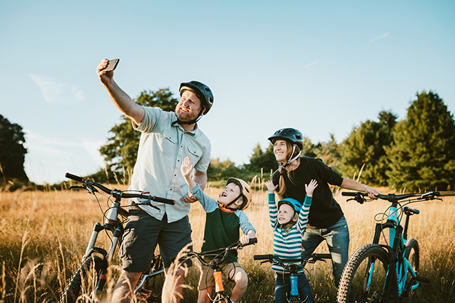 Family taking a photo and cycling around Canberra. 