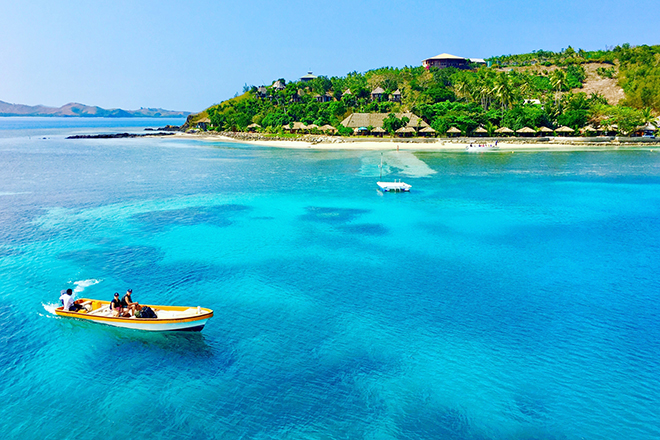 Boat cruising along clear water in Fiji