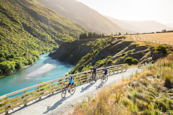 People on a cycling trail in Gibbston Valley near Queenstown, NZ. Enjoy the wind in your hair and phenomenal natural views as you cycle around Queenstown, NZ. Image credit: Tourism NZ, Miles Holden