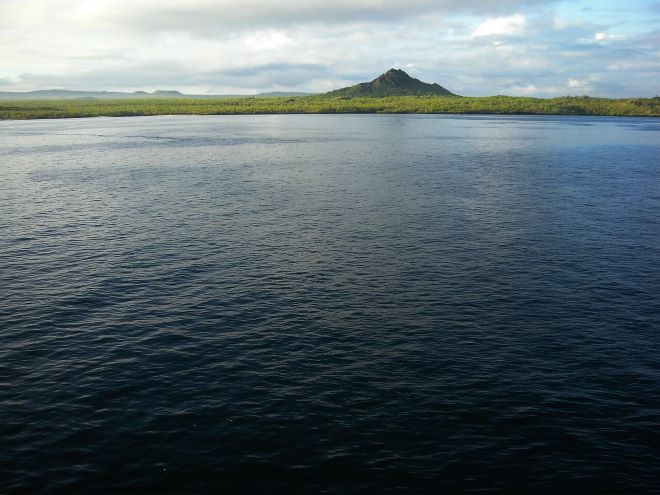 Ilha de Galápagos vista de longe com mar em primeiro plano
