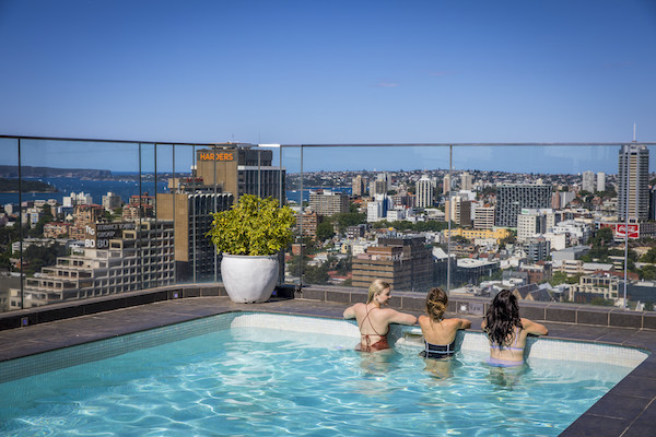 Guests enjoying the pool and view at Pullman Sydney Hyde Park