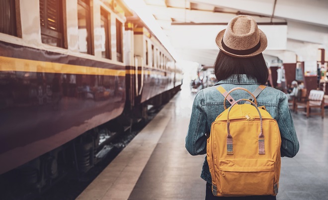 Jovem viajante asiática com mochila na ferrovia, mochila e chapéu na estação de trem com um viajante, conceito de viagem