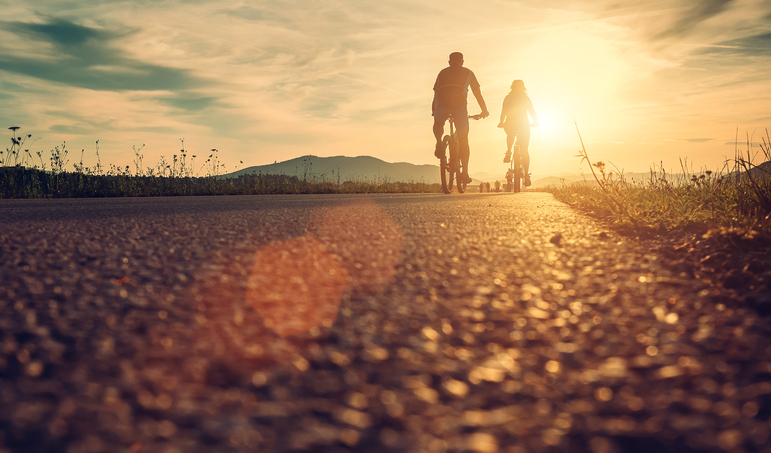 Jovens pedalando ao pôr do sol