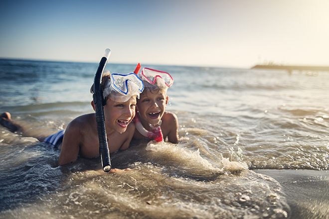 kids playing in the waves at the beach 