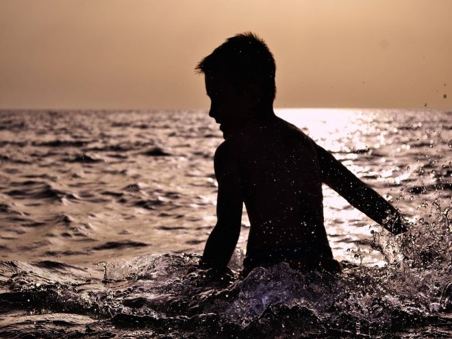 menino tomando banho de mar é um exemplo de foto no mar