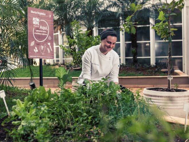 chef de cozinha feliz mexendo na horta orgânica do hotel Mercure Campinas