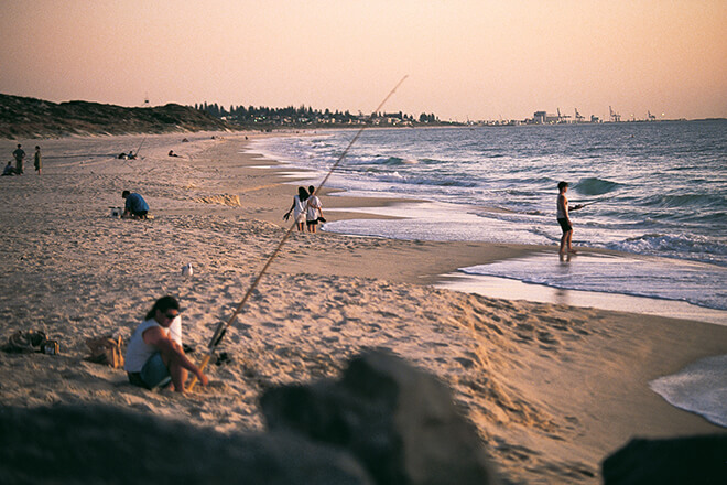 People fishing at City Beach at sunset