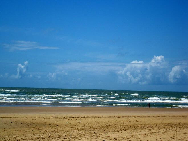Praia Atalaia em Aracaju Sergipe com suas ondas e areias escura e céu azul em destaque