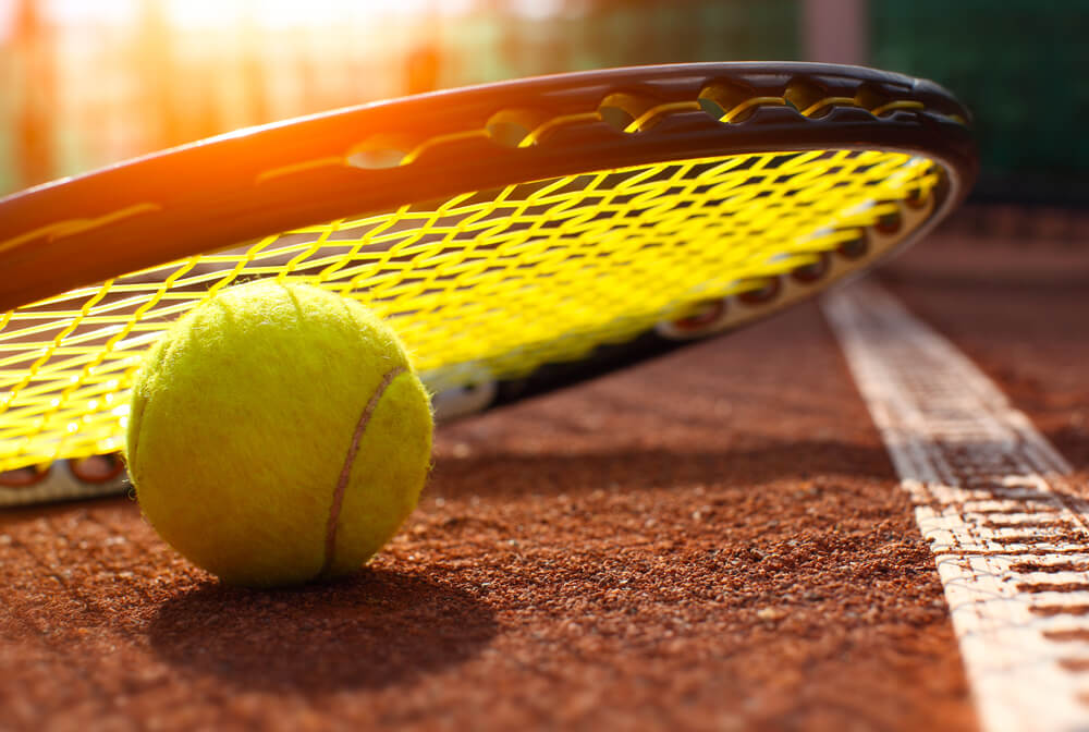 Quadra de tênis com raquete e bola de tênis no chão: os dois  equipamento de tênis de quadra, além da rede