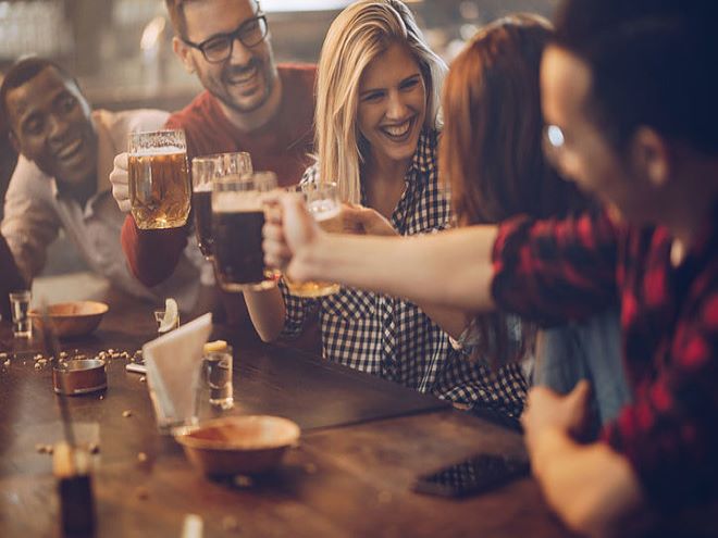 Foto de amigos tomando cerveza artesanal en un pub inglés.