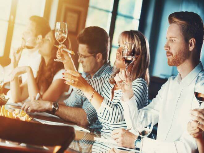 personas en restaurante bebendo vino y celebrando