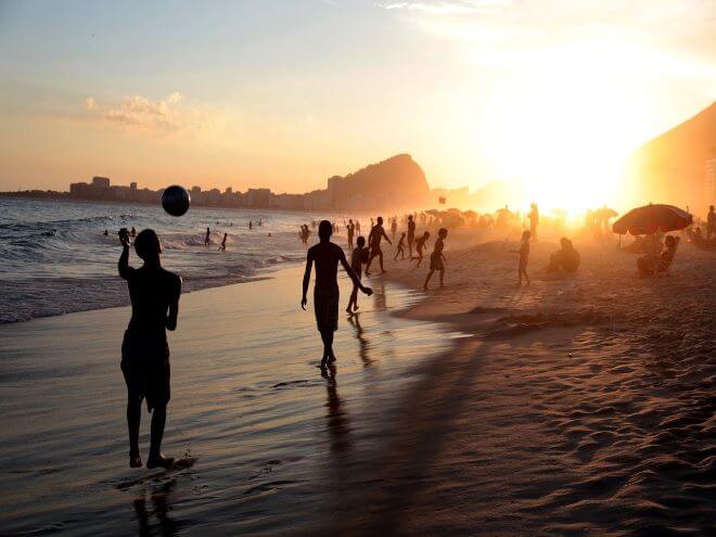 Praia de Copacabana no Rio de Janeiro lotada de banhistas e pessoas na areia