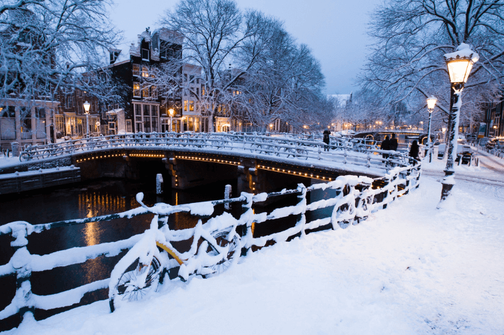 Abendlicht auf den schneebedeckten Straßen und Grachten von Amsterdam