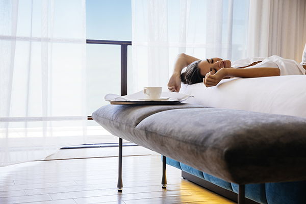 Woman relaxing on a hotel room bed